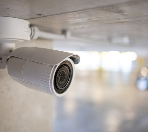 Close-up of surveillance camera in underground parking space.